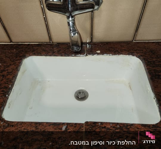 כיור עם ברז מותקן על משטח שיש